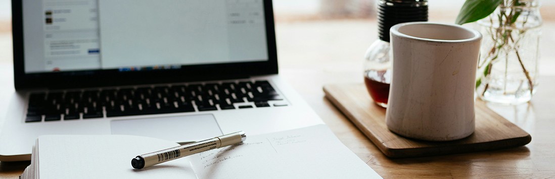 Eine Wissenschaftlerin und ein Wissenschaftler arbeiten hinter einer Glasfassade und mischen Chemikalien mit Großgeräten.